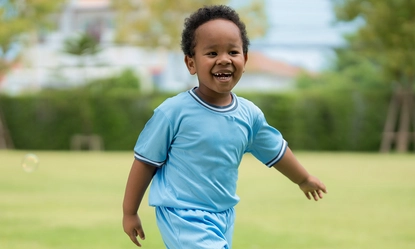 cute-little-boy-playing-with-soap-bubbles-park-clear-day 1