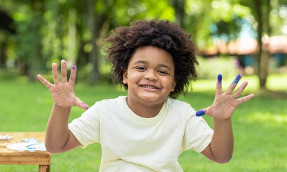 happy-african-american-boy-showing-hands-after-painting-watercolor-white-paper-park