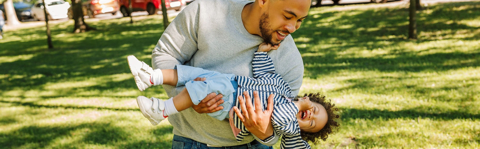 man-carrying-toddler-son-park