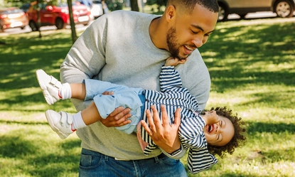 man-carrying-toddler-son-park