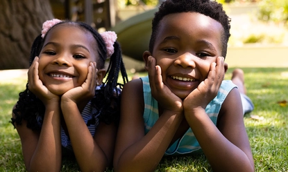 portrait-cute-african-american-siblings-with-hands-chins-lying-grassy-field-park