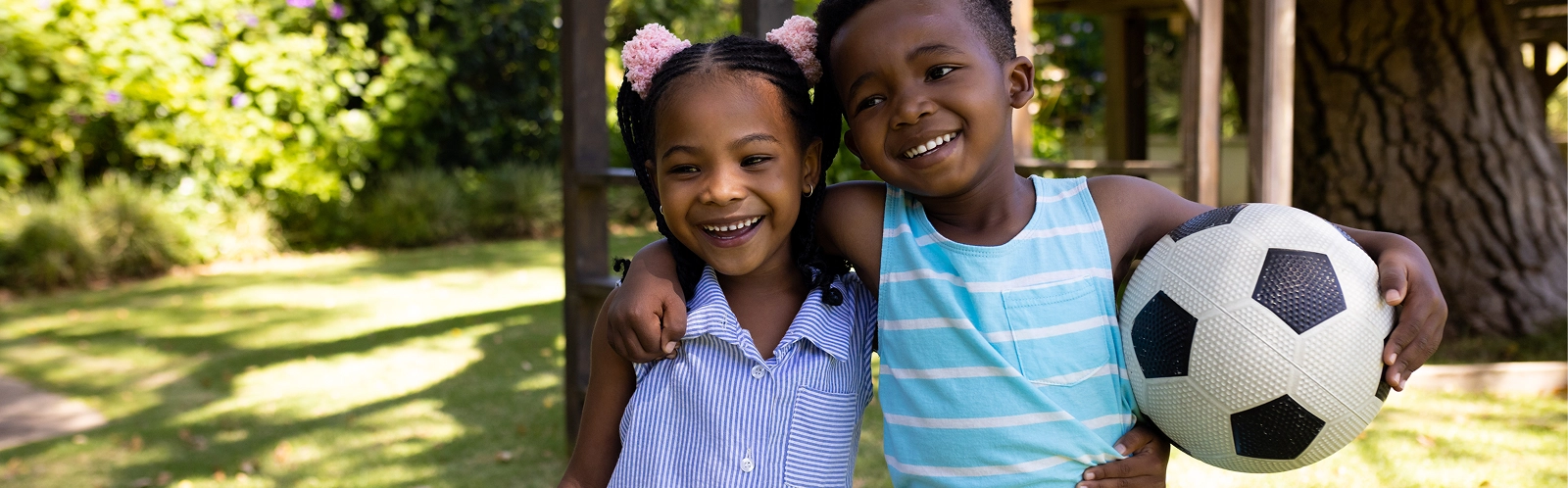 portrait-smiling-african-american-siblings-with-soccer-ball-standing-park