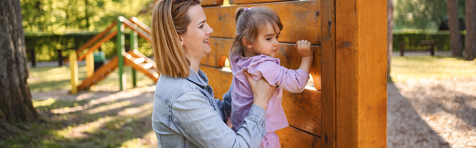 smiling-mom-helps-her-cute-daughter-climb-playground (1)
