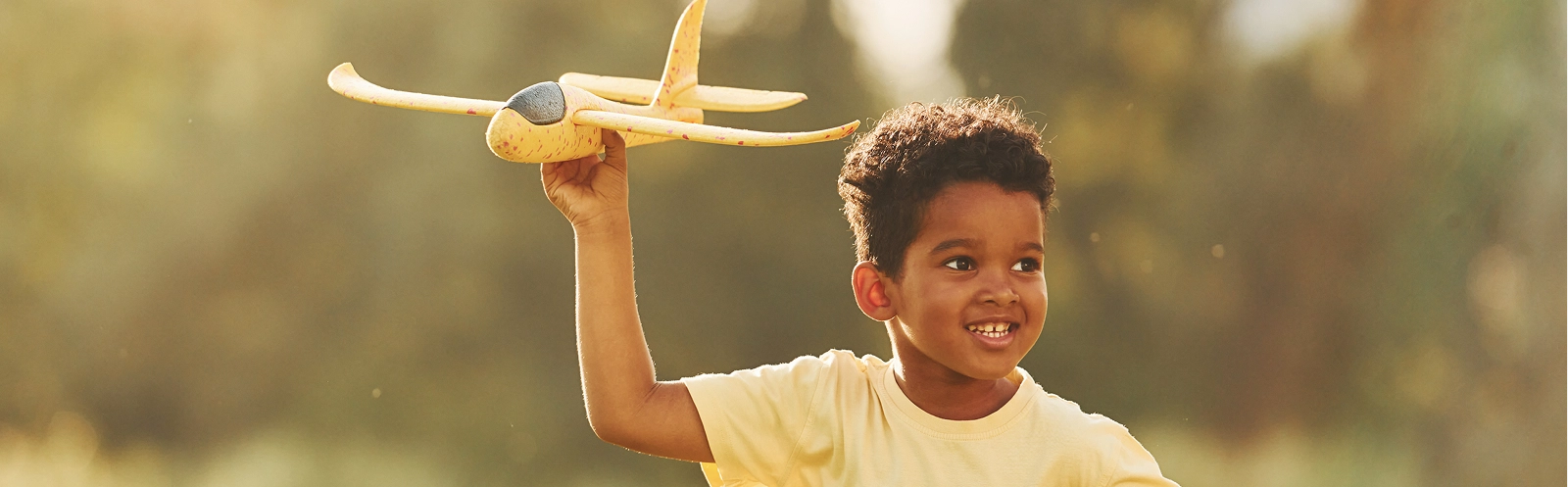 yellow-plane-hands-african-american-kid-have-fun-field-summer-daytime
